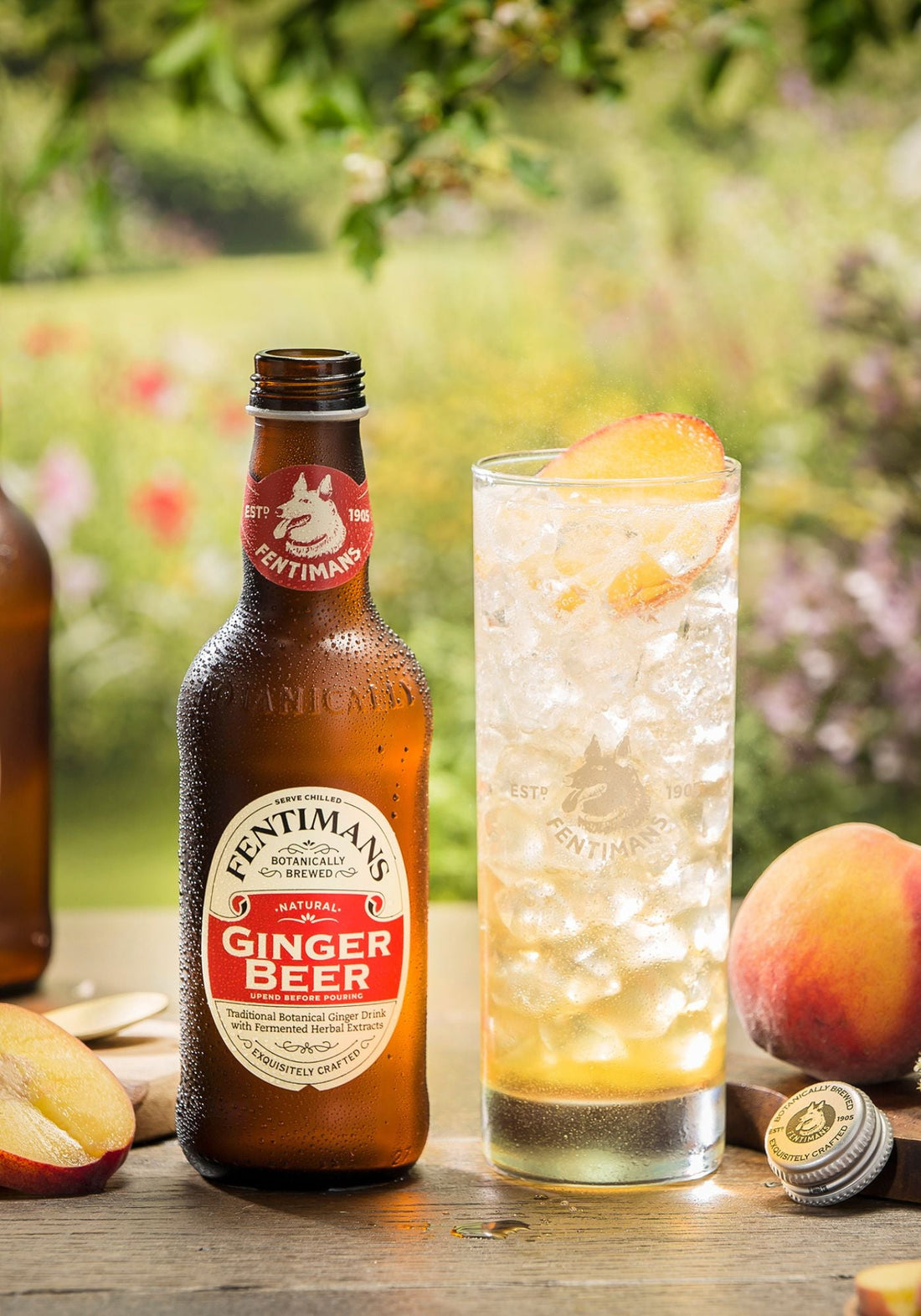 Thanks to Thomas cocktail in a wildflower garden setting beside a bottle of Fentimans Ginger Beer and peaches